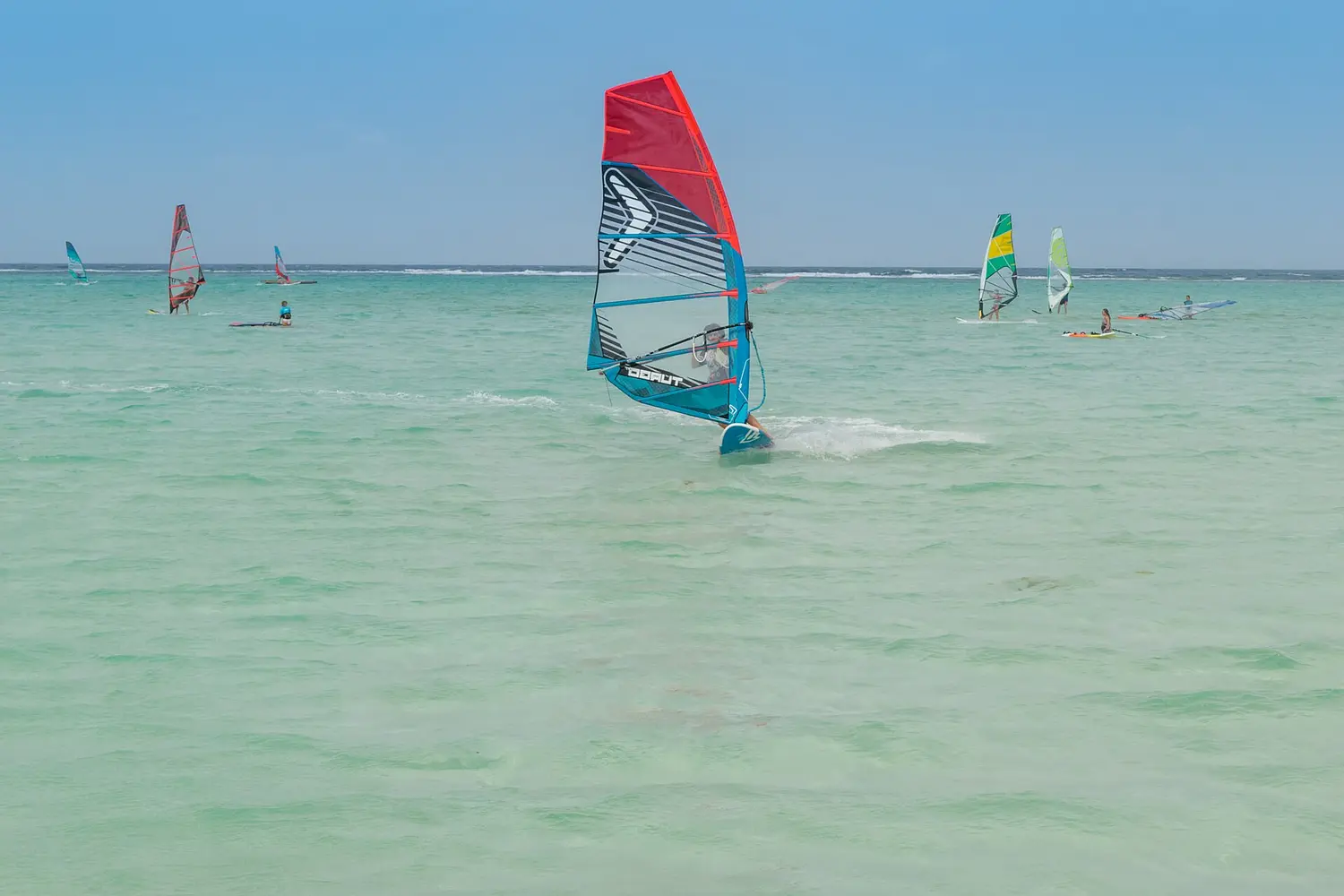 Windsurfers on the shallow lagoon at Lac Bay